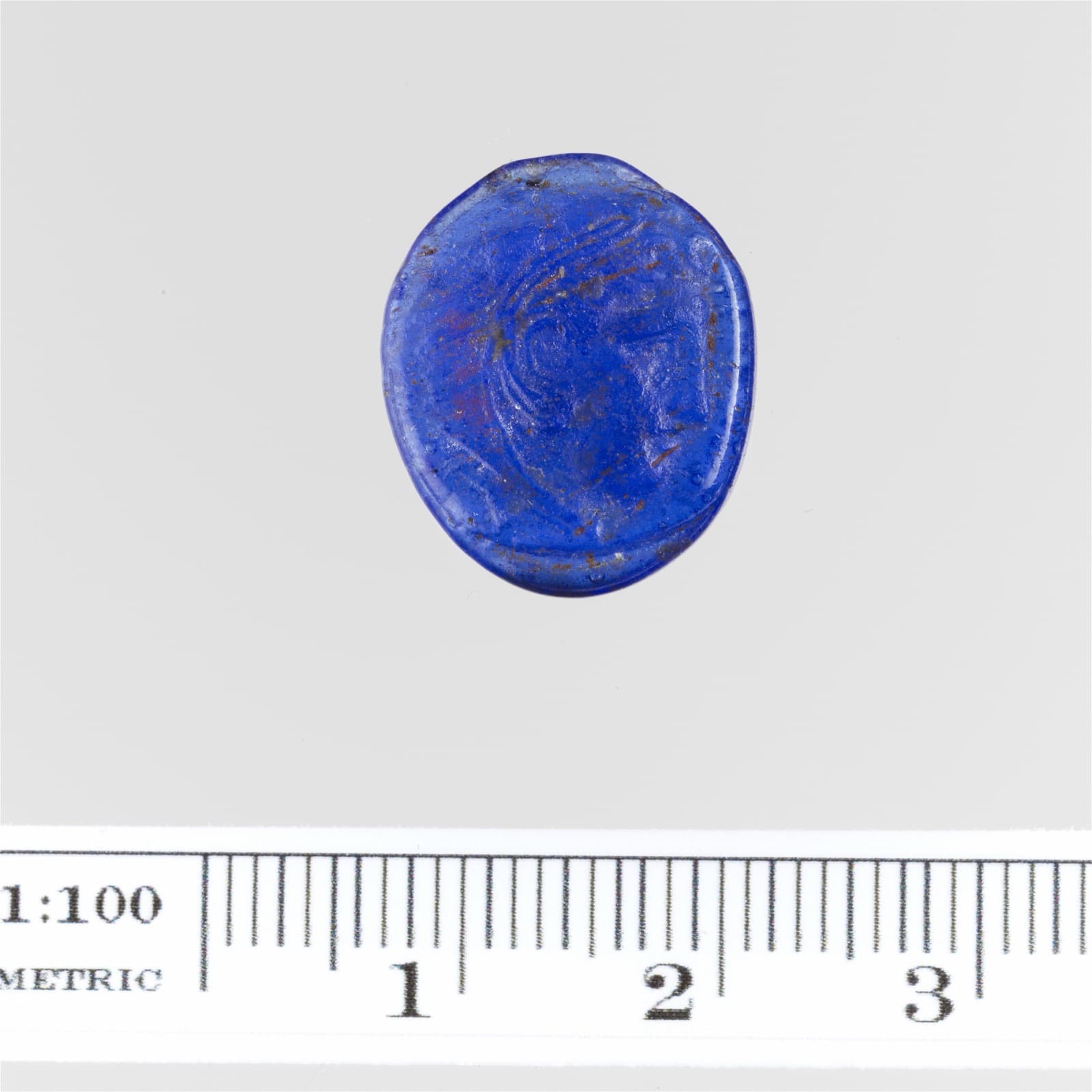 Small oval glass cameo carved with the profile of a man wearing a lion-skin headdress